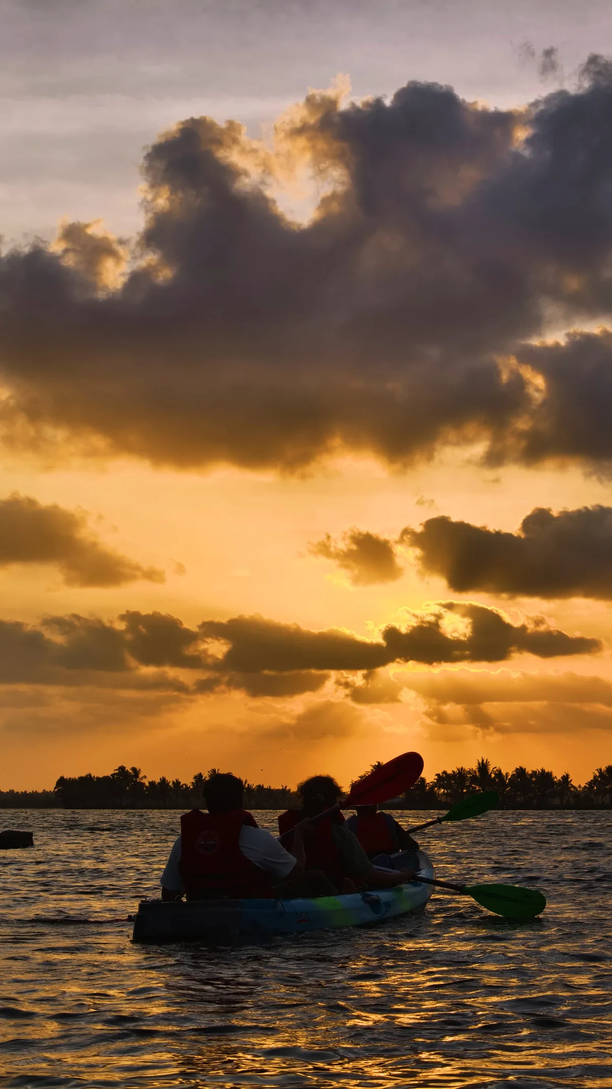 Guest in a yellow kayak at golden hour on Kadamakkudy backwaters